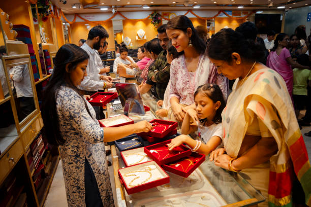 People buy gold ornaments at a jewelry showroom during Dhanteras,, in Guwahati, India on 29 October 2024. On Dhanteras, people traditionally buy precious metals like gold, silver, or even new utensils, as its believed this brings wealth and good luck into the household.